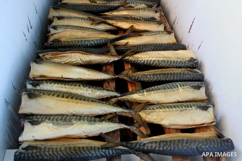 Mackerels are being smoked by Palestinians before selling them at a market ahead of the Eid al-Fitr holiday on July 2, 2016 in Khan Yunis, in the southern Gaza Strip. Eid al-Fitr marks the end of Muslim's holy fasting mo...