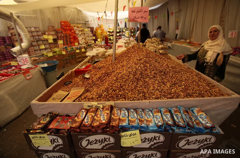 Palestinians shop at a market ahead of the Eid al-Fitr holiday, in the West Bank city of Nablus, on July 3, 2016. Eid al-Fitr marks the end of Muslim's holy fasting month of Ramadan when faithfuls abstain from eating, dr...