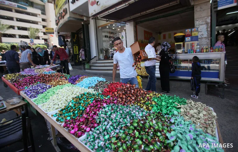 Palestinians shop at a market ahead of the Eid al-Fitr holiday, in the West Bank city of Nablus, on July 3, 2016. Eid al-Fitr marks the end of Muslim's holy fasting month of Ramadan when faithfuls abstain from eating, dr...