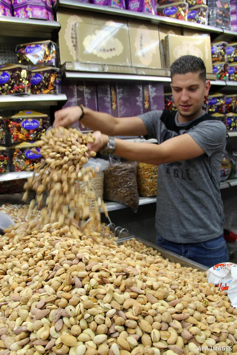 Palestinians shop at a market ahead of the Eid al-Fitr holiday, in Jerusalem old city, on July 3, 2016. Eid al-Fitr marks the end of Muslim's holy fasting month of Ramadan when faithfuls abstain from eating, drinking, sm...