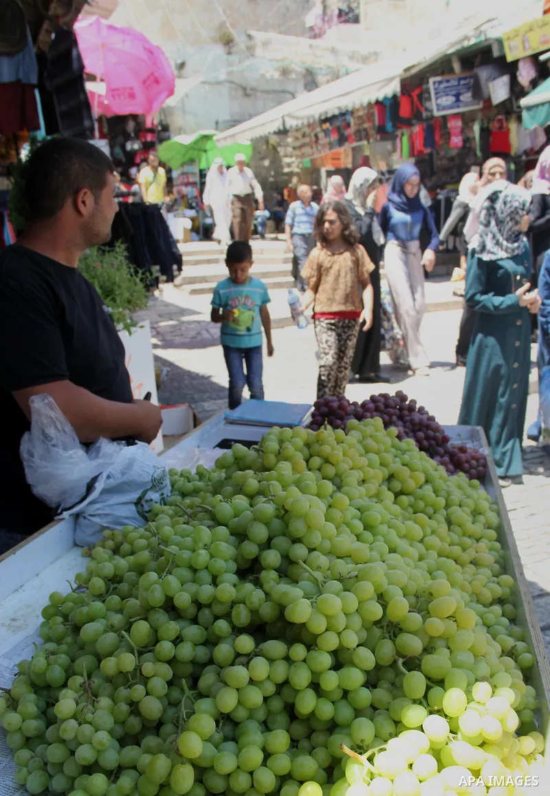 Palestinians shop at a market ahead of the Eid al-Fitr holiday, in Jerusalem old city, on July 3, 2016. Eid al-Fitr marks the end of Muslim's holy fasting month of Ramadan when faithfuls abstain from eating, drinking, sm...