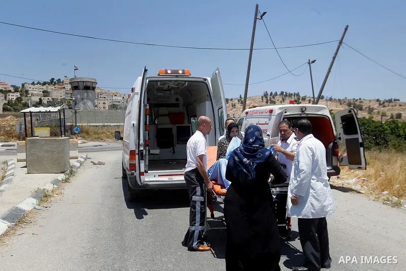 Palestinians wait to enter the ambulance from a barrier blocking the road at a southern entrance of Hebron on July 3, 2016, as the army keeps the town under lockdown following clashes and attacks that killed two Israelis...