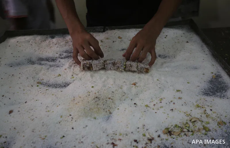 Palestinians prepare sweet known in Arabic as "Halkoum" ahead of the Eid al-Fitr holiday, in Gaza city, on July 3, 2016. Eid al-Fitr marks the end of Muslim's holy fasting month of Ramadan when faithfuls abstain from eat...