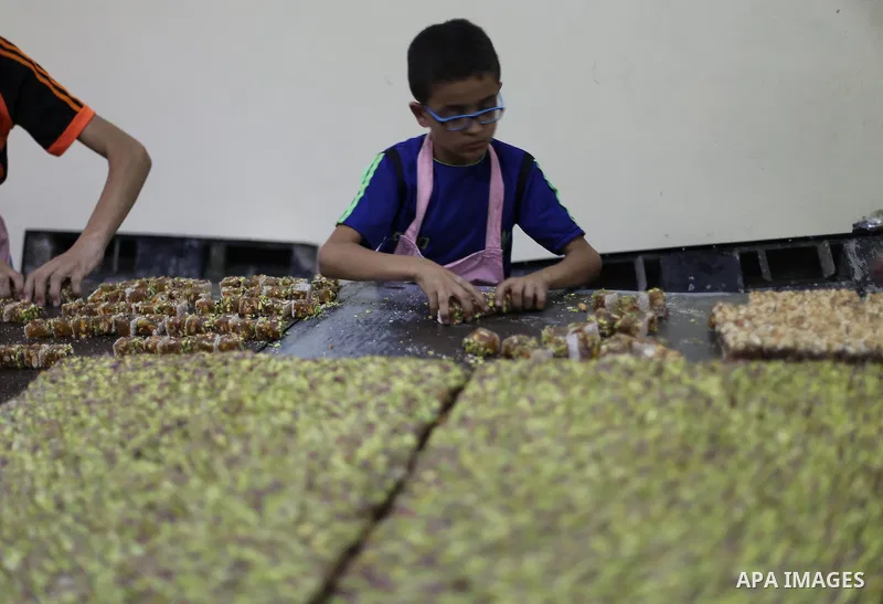 Palestinians prepare sweet known in Arabic as "Halkoum" ahead of the Eid al-Fitr holiday, in Gaza city, on July 3, 2016. Eid al-Fitr marks the end of Muslim's holy fasting month of Ramadan when faithfuls abstain from eat...