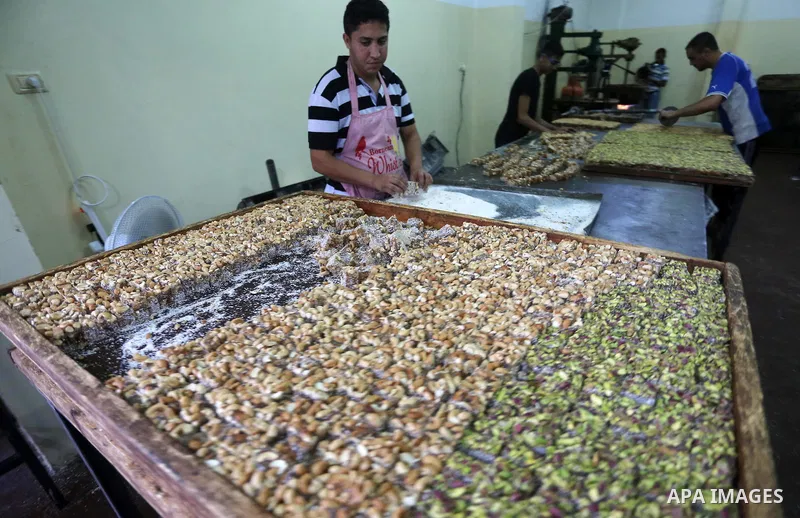 Palestinians prepare sweet known in Arabic as "Halkoum" ahead of the Eid al-Fitr holiday, in Gaza city, on July 3, 2016. Eid al-Fitr marks the end of Muslim's holy fasting month of Ramadan when faithfuls abstain from eat...