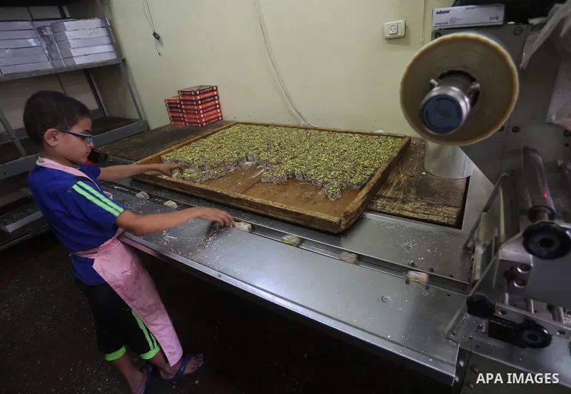 Palestinians prepare sweet known in Arabic as "Halkoum" ahead of the Eid al-Fitr holiday, in Gaza city, on July 3, 2016. Eid al-Fitr marks the end of Muslim's holy fasting month of Ramadan when faithfuls abstain from eat...