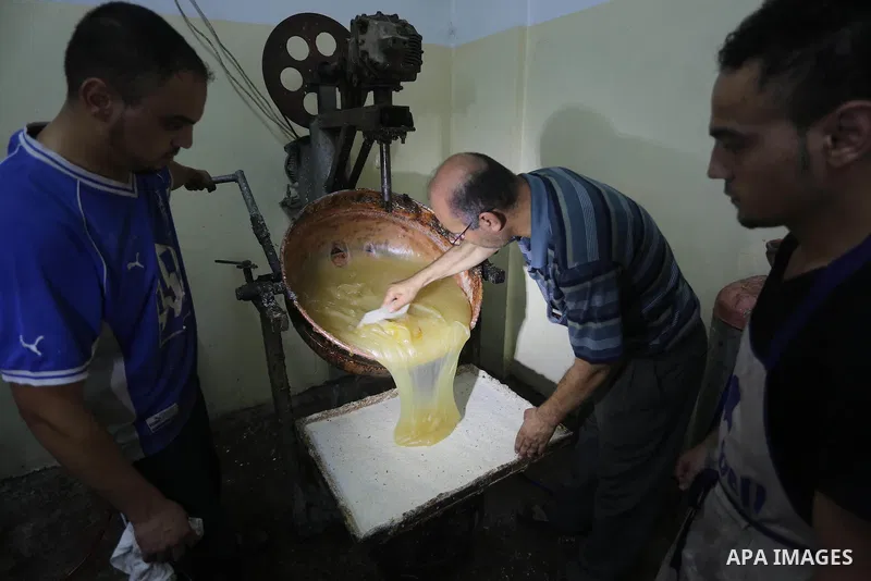 Palestinians prepare sweet known in Arabic as "Halkoum" ahead of the Eid al-Fitr holiday, in Gaza city, on July 3, 2016. Eid al-Fitr marks the end of Muslim's holy fasting month of Ramadan when faithfuls abstain from eat...