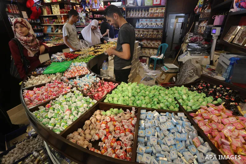 Palestinians sell chocolate at a shop ahead of the Eid al-Fitr holiday, in Gaza city, on July 3, 2016. Eid al-Fitr marks the end of Muslim's holy fasting month of Ramadan when faithfuls abstain from eating, drinking, smo...