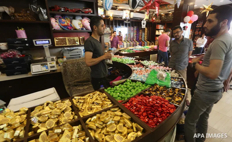 Palestinians sell chocolate at a shop ahead of the Eid al-Fitr holiday, in Gaza city, on July 3, 2016. Eid al-Fitr marks the end of Muslim's holy fasting month of Ramadan when faithfuls abstain from eating, drinking, smo...