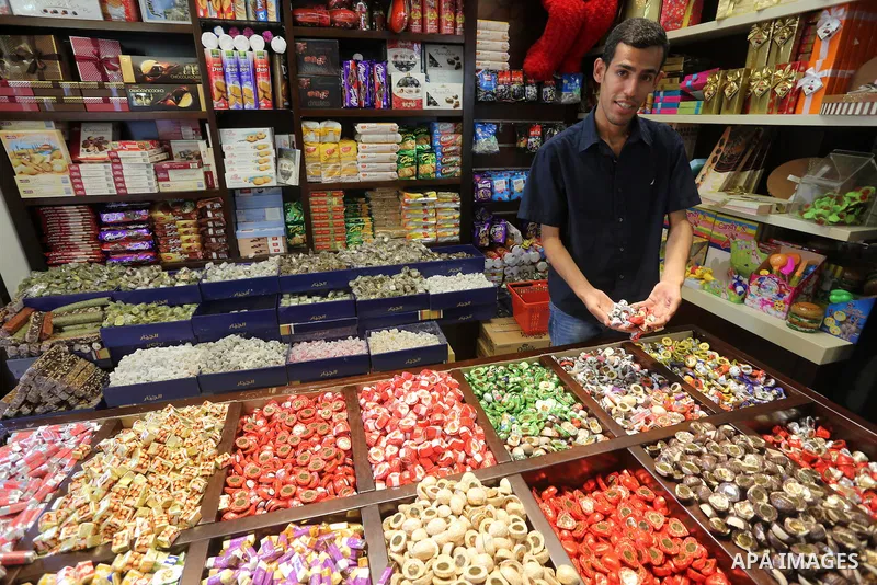 Palestinians sell chocolate at a shop ahead of the Eid al-Fitr holiday, in Gaza city, on July 3, 2016. Eid al-Fitr marks the end of Muslim's holy fasting month of Ramadan when faithfuls abstain from eating, drinking, smo...