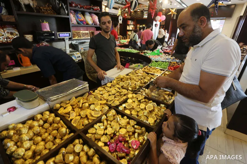 Palestinians sell chocolate at a shop ahead of the Eid al-Fitr holiday, in Gaza city, on July 3, 2016. Eid al-Fitr marks the end of Muslim's holy fasting month of Ramadan when faithfuls abstain from eating, drinking, smo...