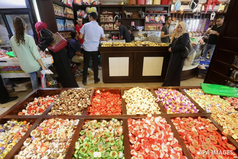 Palestinians sell chocolate at a shop ahead of the Eid al-Fitr holiday, in Gaza city, on July 3, 2016. Eid al-Fitr marks the end of Muslim's holy fasting month of Ramadan when faithfuls abstain from eating, drinking, smo...