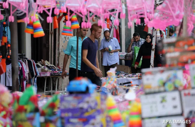Palestinians shop at a market ahead of the Eid al-Fitr holiday, in Gaza city, on July 4, 2016. Eid al-Fitr marks the end of Muslim's holy fasting month of Ramadan when faithfuls abstain from eating, drinking, smoking and...