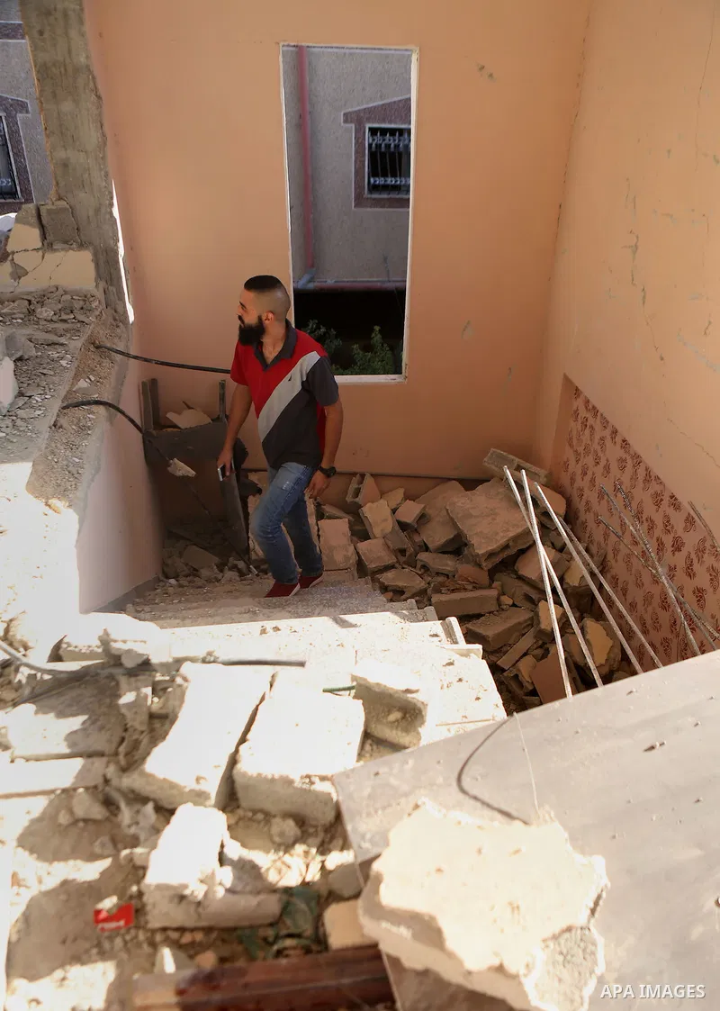 Palestinians inspect the damaged house of Anan Abu Habsa, which was demolished by the Israeli army, in the West Bank refugee camp of Qalandia, at the outskirts of Ramallah, Monday, July 4, 2016. The Israeli army demolish...
