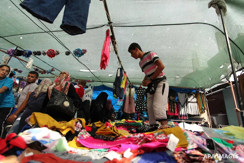 Palestinians shop at a market ahead of the Eid al-Fitr holiday, in Nuseirat refugee camp in the central Gaza Strip, on July 4, 2016. Eid al-Fitr marks the end of Muslim's holy fasting month of Ramadan when faithfuls abst...