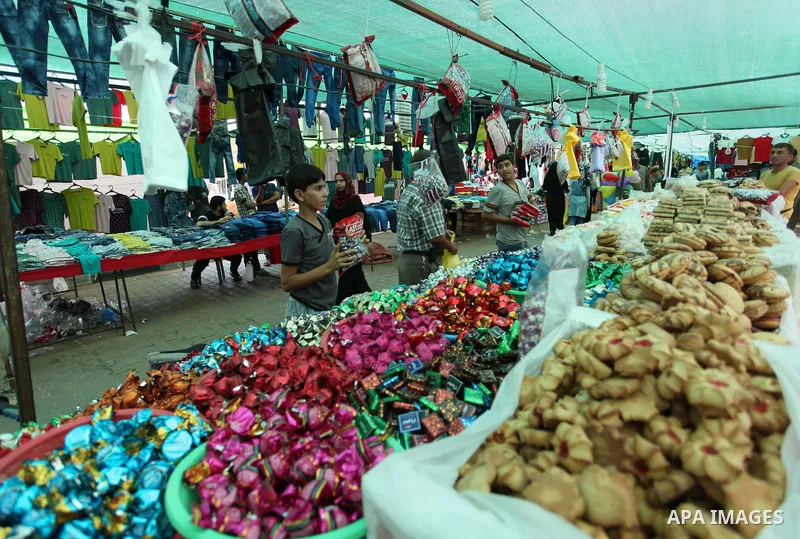 Palestinians shop at a market ahead of the Eid al-Fitr holiday, in Nuseirat refugee camp in the central Gaza Strip, on July 4, 2016. Eid al-Fitr marks the end of Muslim's holy fasting month of Ramadan when faithfuls abst...