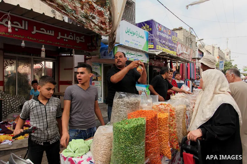 Palestinians shop at a market ahead of the Eid al-Fitr holiday, in Nuseirat refugee camp in the central Gaza Strip, on July 4, 2016. Eid al-Fitr marks the end of Muslim's holy fasting month of Ramadan when faithfuls abst...