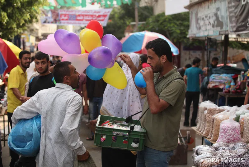 Palestinians shop at a market ahead of the Eid al-Fitr holiday, in Nuseirat refugee camp in the central Gaza Strip, on July 4, 2016. Eid al-Fitr marks the end of Muslim's holy fasting month of Ramadan when faithfuls abst...