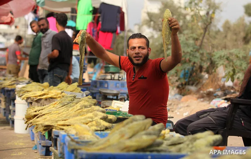A Palestinian vendor displays salted fish at a market ahead of the Eid al-Fitr holiday, in Nuseirat refugee camp in the central Gaza Strip, on July 4, 2016. Eid al-Fitr marks the end of Muslim's holy fasting month of Ram...