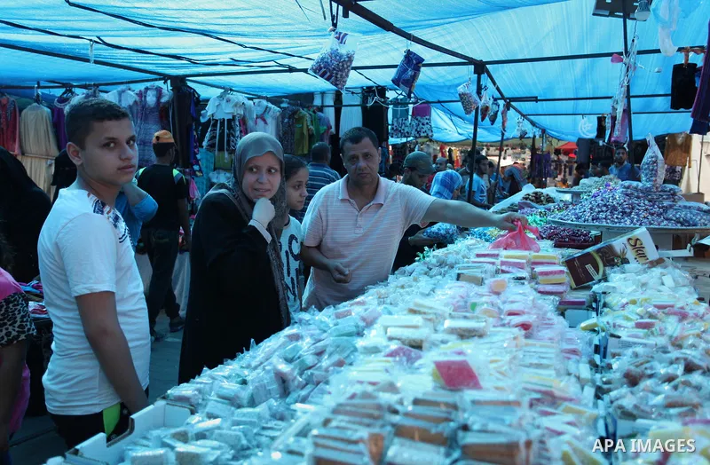 Palestinians shop at a market ahead of the Eid al-Fitr holiday, in Nuseirat refugee camp in the central Gaza Strip, on July 4, 2016. Eid al-Fitr marks the end of Muslim's holy fasting month of Ramadan when faithfuls abst...