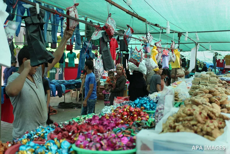 Palestinians shop at a market ahead of the Eid al-Fitr holiday, in Nuseirat refugee camp in the central Gaza Strip, on July 4, 2016. Eid al-Fitr marks the end of Muslim's holy fasting month of Ramadan when faithfuls abst...