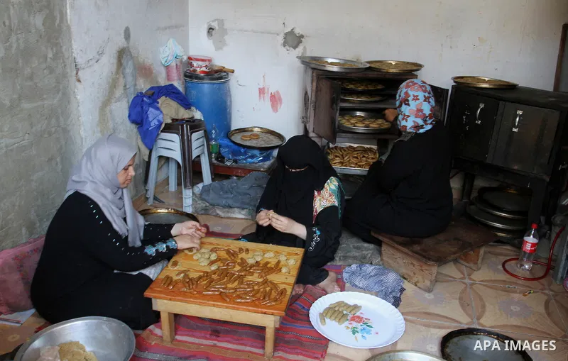 Palestinian women prepare date-filled mini cakes traditional for the Eid al-Fitr, a three-day holiday that marks the end of the fasting month of Ramadan, in Rafah in the southern Gaza Strip on July 4, 2016, as Muslims th...