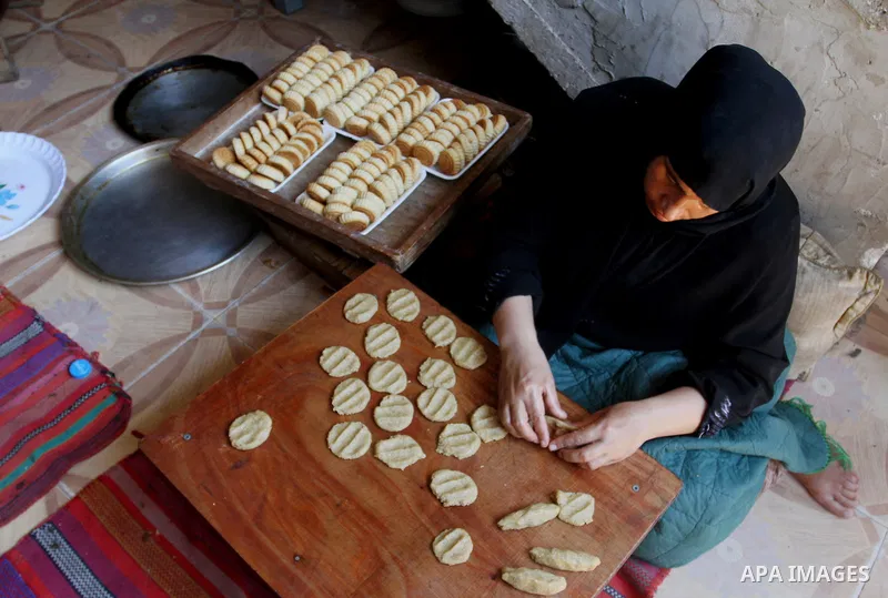 Palestinian women prepare date-filled mini cakes traditional for the Eid al-Fitr, a three-day holiday that marks the end of the fasting month of Ramadan, in Rafah in the southern Gaza Strip on July 4, 2016, as Muslims th...