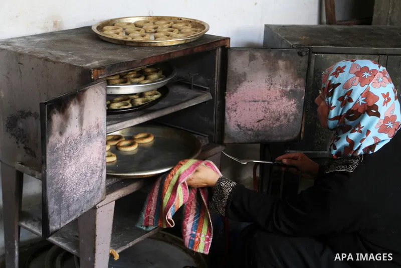 Palestinian women prepare date-filled mini cakes traditional for the Eid al-Fitr, a three-day holiday that marks the end of the fasting month of Ramadan, in Rafah in the southern Gaza Strip on July 4, 2016, as Muslims th...