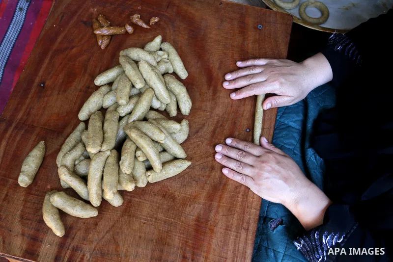 Palestinian women prepare date-filled mini cakes traditional for the Eid al-Fitr, a three-day holiday that marks the end of the fasting month of Ramadan, in Rafah in the southern Gaza Strip on July 4, 2016, as Muslims th...