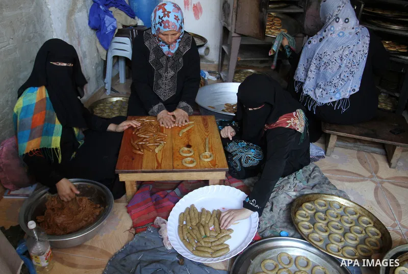 Palestinian women prepare date-filled mini cakes traditional for the Eid al-Fitr, a three-day holiday that marks the end of the fasting month of Ramadan, in Rafah in the southern Gaza Strip on July 4, 2016, as Muslims th...