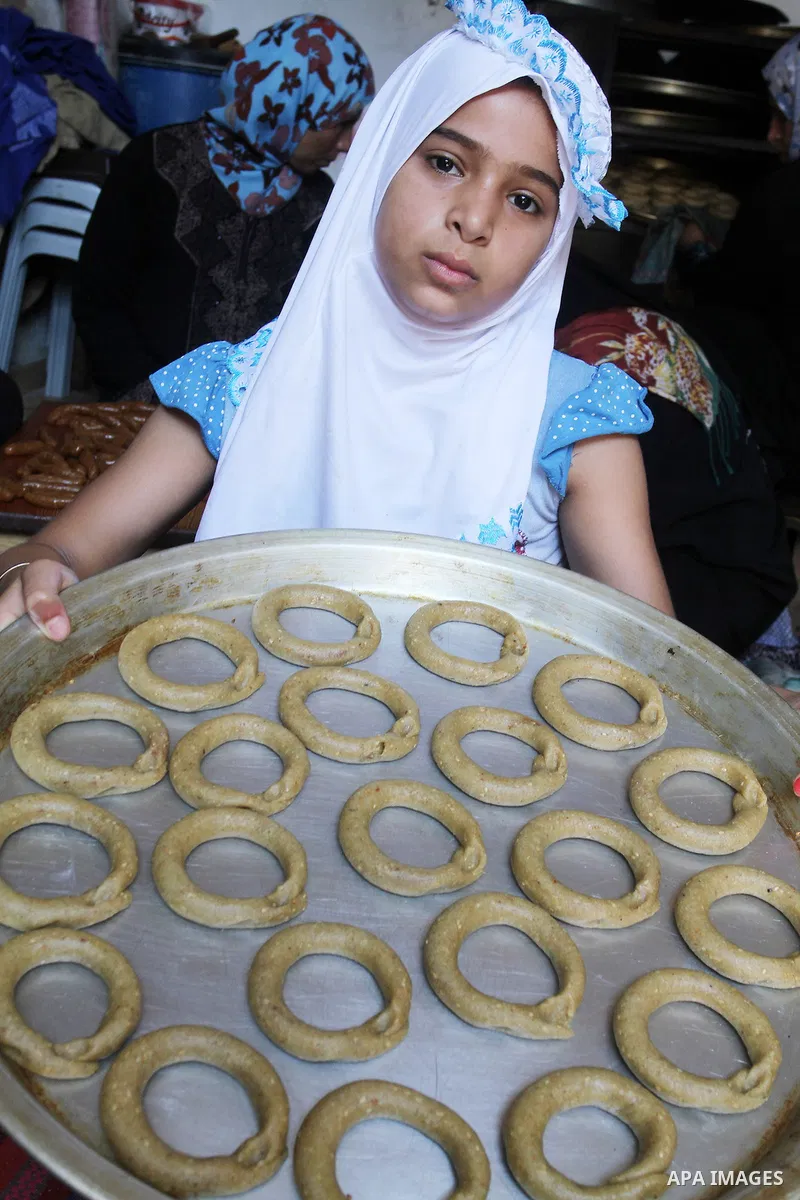 Palestinian women prepare date-filled mini cakes traditional for the Eid al-Fitr, a three-day holiday that marks the end of the fasting month of Ramadan, in Rafah in the southern Gaza Strip on July 4, 2016, as Muslims th...