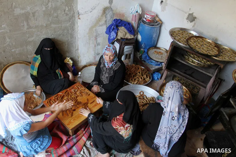 Palestinian women prepare date-filled mini cakes traditional for the Eid al-Fitr, a three-day holiday that marks the end of the fasting month of Ramadan, in Rafah in the southern Gaza Strip on July 4, 2016, as Muslims th...