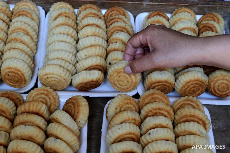 Palestinian women prepare date-filled mini cakes traditional for the Eid al-Fitr, a three-day holiday that marks the end of the fasting month of Ramadan, in Rafah in the southern Gaza Strip on July 4, 2016, as Muslims th...