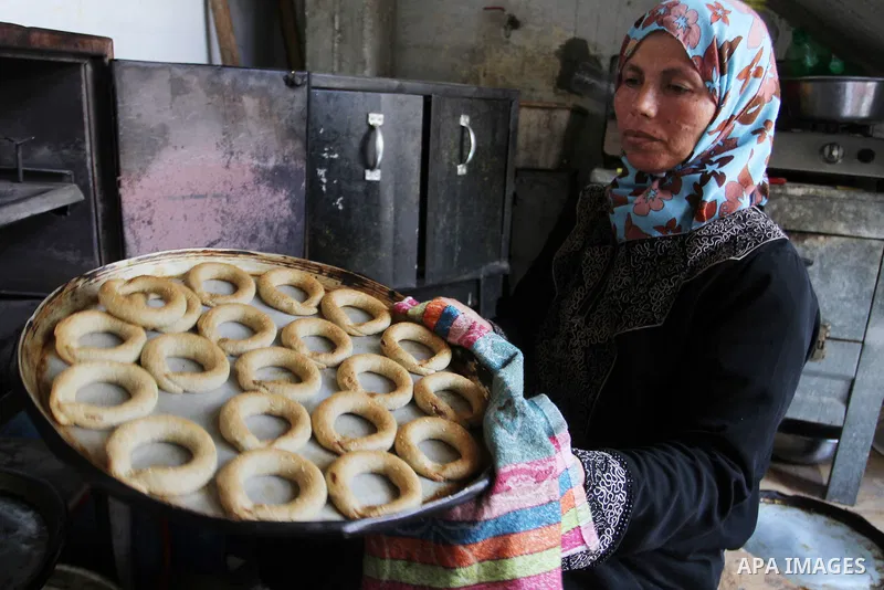 Palestinian women prepare date-filled mini cakes traditional for the Eid al-Fitr, a three-day holiday that marks the end of the fasting month of Ramadan, in Rafah in the southern Gaza Strip on July 4, 2016, as Muslims th...