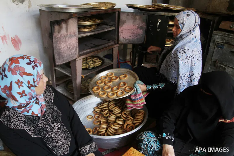 Palestinian women prepare date-filled mini cakes traditional for the Eid al-Fitr, a three-day holiday that marks the end of the fasting month of Ramadan, in Rafah in the southern Gaza Strip on July 4, 2016, as Muslims th...
