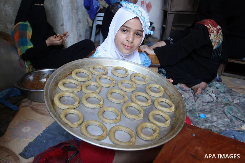Palestinian women prepare date-filled mini cakes traditional for the Eid al-Fitr, a three-day holiday that marks the end of the fasting month of Ramadan, in Rafah in the southern Gaza Strip on July 4, 2016, as Muslims th...