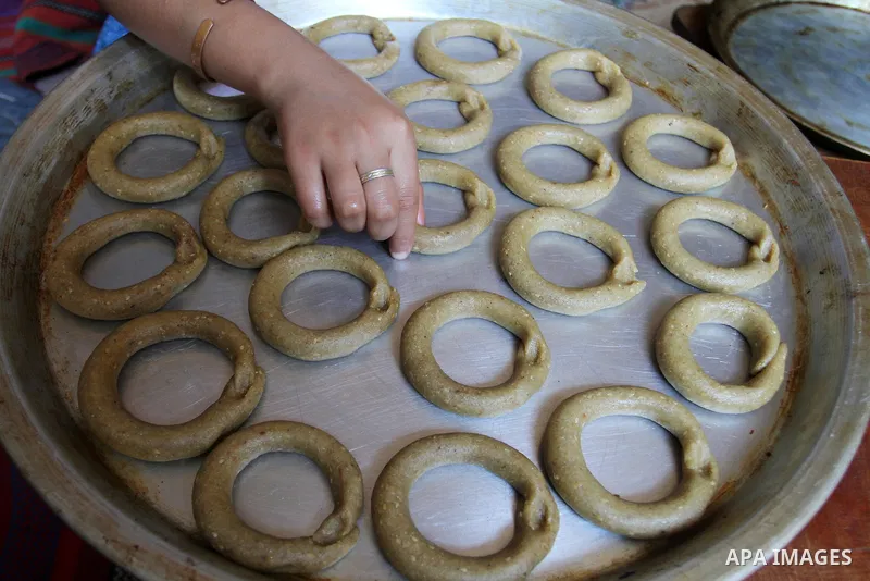 Palestinian women prepare date-filled mini cakes traditional for the Eid al-Fitr, a three-day holiday that marks the end of the fasting month of Ramadan, in Rafah in the southern Gaza Strip on July 4, 2016, as Muslims th...