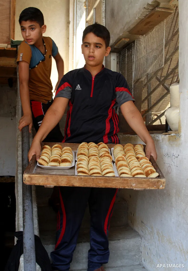 Palestinian women prepare date-filled mini cakes traditional for the Eid al-Fitr, a three-day holiday that marks the end of the fasting month of Ramadan, in Rafah in the southern Gaza Strip on July 4, 2016, as Muslims th...