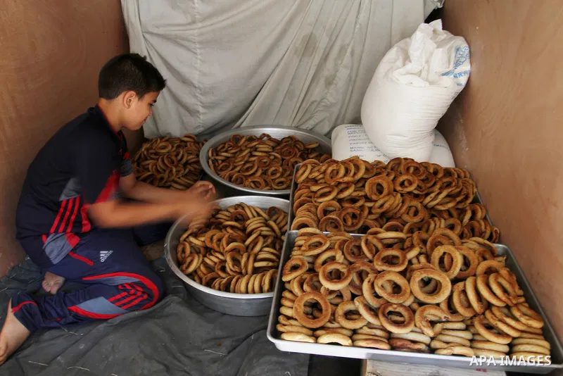 Palestinian women prepare date-filled mini cakes traditional for the Eid al-Fitr, a three-day holiday that marks the end of the fasting month of Ramadan, in Rafah in the southern Gaza Strip on July 4, 2016, as Muslims th...