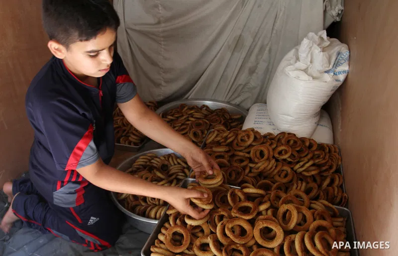 Palestinian women prepare date-filled mini cakes traditional for the Eid al-Fitr, a three-day holiday that marks the end of the fasting month of Ramadan, in Rafah in the southern Gaza Strip on July 4, 2016, as Muslims th...