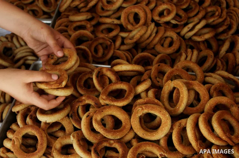 Palestinian women prepare date-filled mini cakes traditional for the Eid al-Fitr, a three-day holiday that marks the end of the fasting month of Ramadan, in Rafah in the southern Gaza Strip on July 4, 2016, as Muslims th...