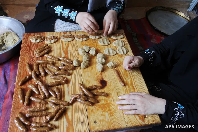 Palestinian women prepare date-filled mini cakes traditional for the Eid al-Fitr, a three-day holiday that marks the end of the fasting month of Ramadan, in Rafah in the southern Gaza Strip on July 4, 2016, as Muslims th...