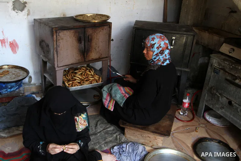 Palestinian women prepare date-filled mini cakes traditional for the Eid al-Fitr, a three-day holiday that marks the end of the fasting month of Ramadan, in Rafah in the southern Gaza Strip on July 4, 2016, as Muslims th...