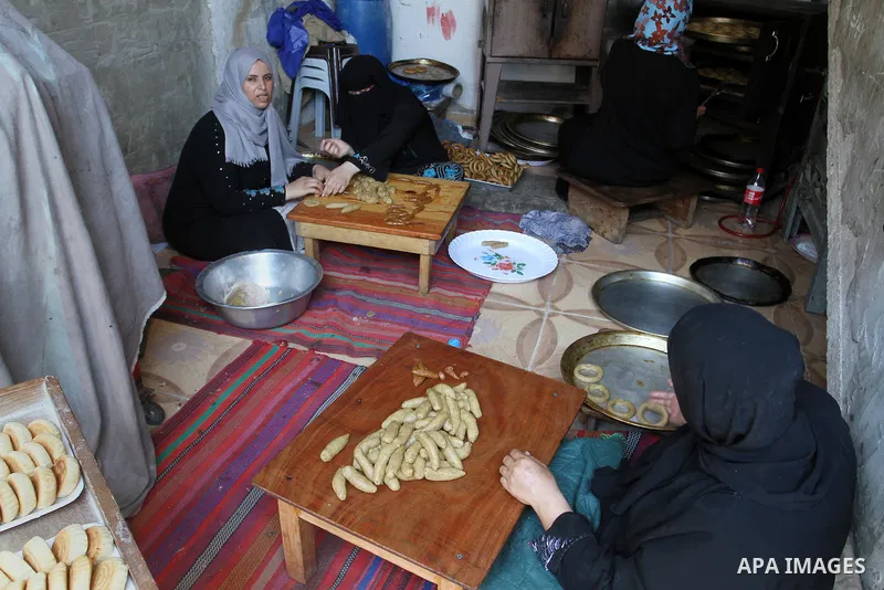 Palestinian women prepare date-filled mini cakes traditional for the Eid al-Fitr, a three-day holiday that marks the end of the fasting month of Ramadan, in Rafah in the southern Gaza Strip on July 4, 2016, as Muslims th...