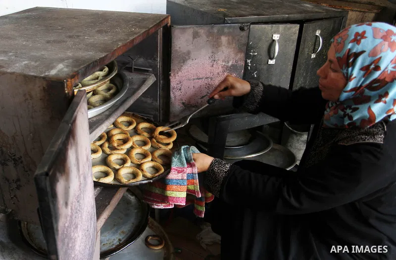 Palestinian women prepare date-filled mini cakes traditional for the Eid al-Fitr, a three-day holiday that marks the end of the fasting month of Ramadan, in Rafah in the southern Gaza Strip on July 4, 2016, as Muslims th...