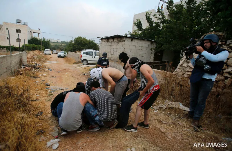 Masked Palestinian men carry a comrade during clashes between Palestinian protesters and Israeli security forces in the village of Dura near the Israeli occupied West Bank city of Hebron, July 4, 2016. Israeli troops loc...