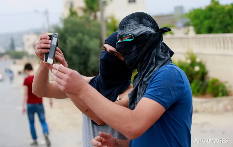 Masked Palestinian men take a selfie during clashes between Palestinian protesters and Israeli security forces in the village of Dura near the Israeli occupied West Bank city of Hebron, July 4, 2016. Israeli troops locke...