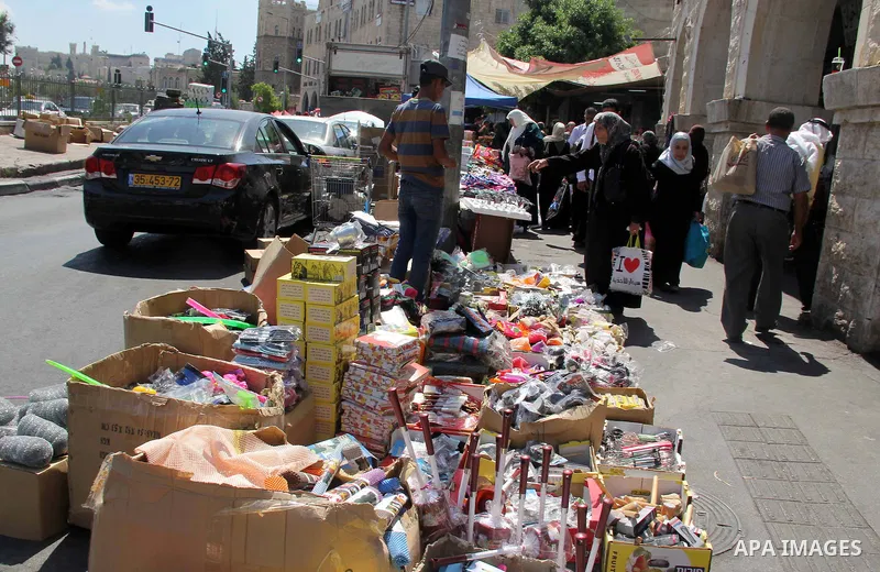 Palestinians shop at a market ahead of the Eid al-Fitr holiday, in Jerusalem old city, on July 3, 2016. Eid al-Fitr marks the end of Muslim's holy fasting month of Ramadan when faithfuls abstain from eating, drinking, sm...