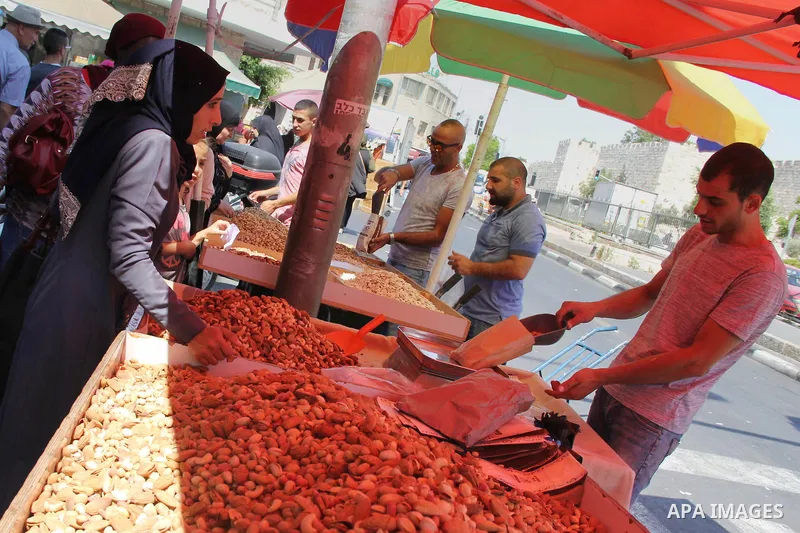 Palestinians shop at a market ahead of the Eid al-Fitr holiday, in Jerusalem old city, on July 3, 2016. Eid al-Fitr marks the end of Muslim's holy fasting month of Ramadan when faithfuls abstain from eating, drinking, sm...