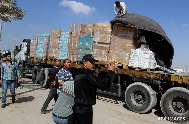 Palestinians check Turkish aid shipments upon arrival in the Gaza Strip at Kerem Shalom crossing between Israel and southern Gaza Strip July 4, 2016. A Turkish ship carrying aid for Gaza arrived in Israel on July 3, a we...